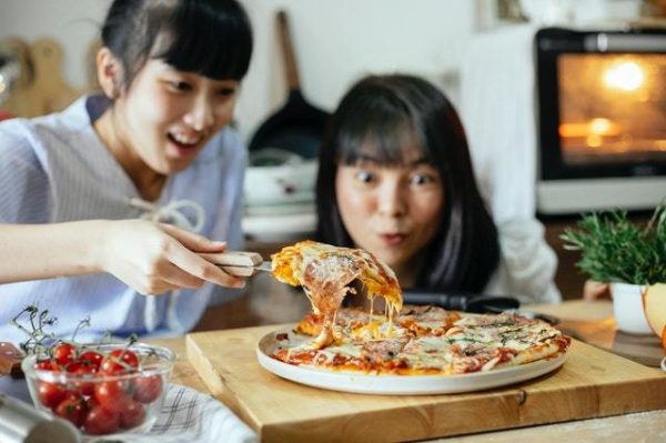 Pizza con mujeres orientales que aman la pizza
